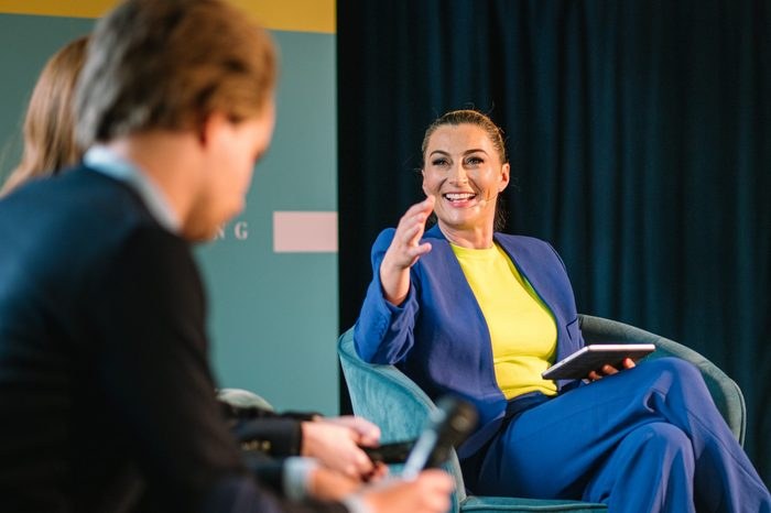 Katrin-Cécile Ziegler moderiert ein Gespräch im blauen Blazer